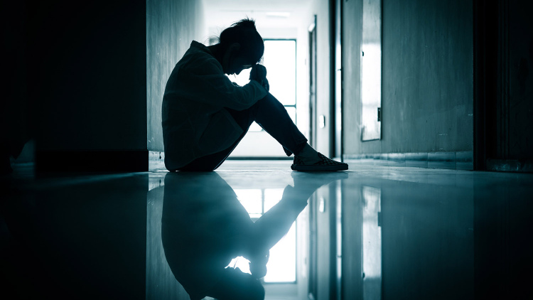 Lonely teen in a dim hallway