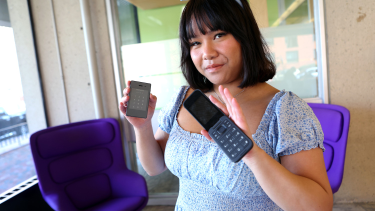 Photo of Gabriela Nguyen holding two phones