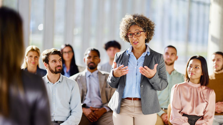 A woman speaks in front of an audience of educators
