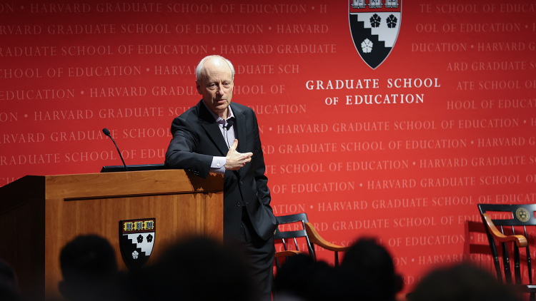 Harvard professor Michael Sandel stands at the podium in Askwith Hall.