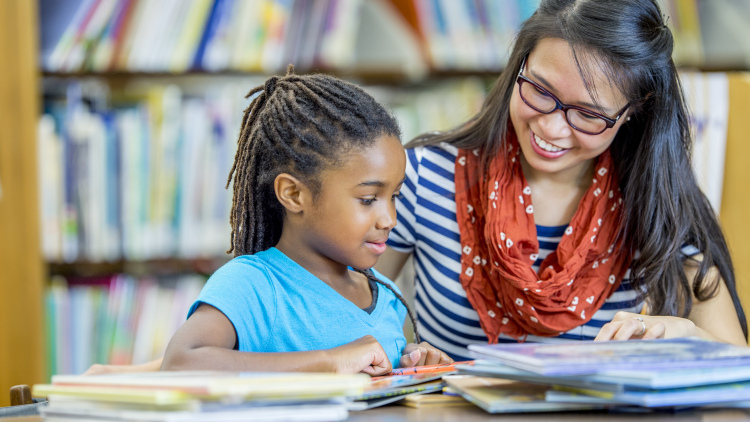 Tutor with student in school library