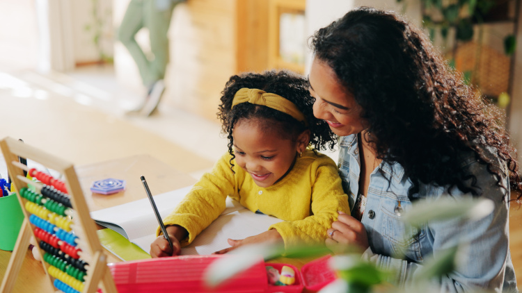 Mom helps young daughter with school work 