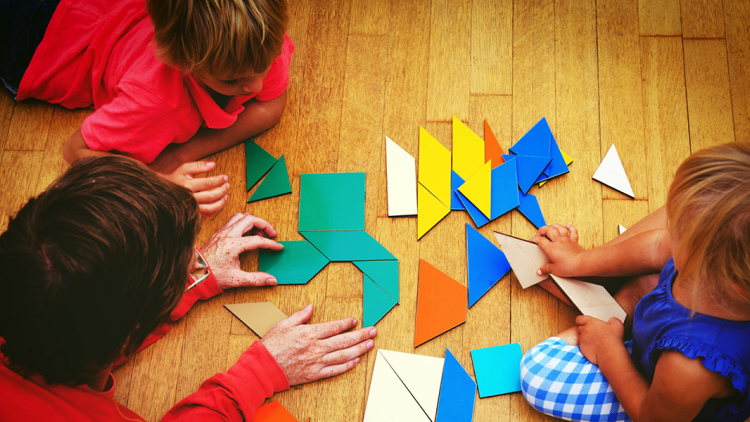 Preschoolers doing puzzle on floor