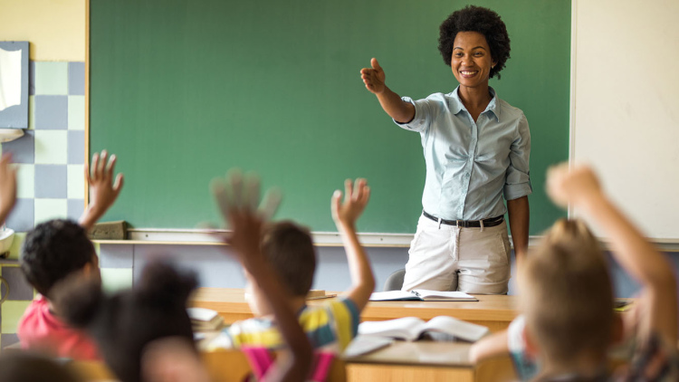 Teacher standing happily in front of class