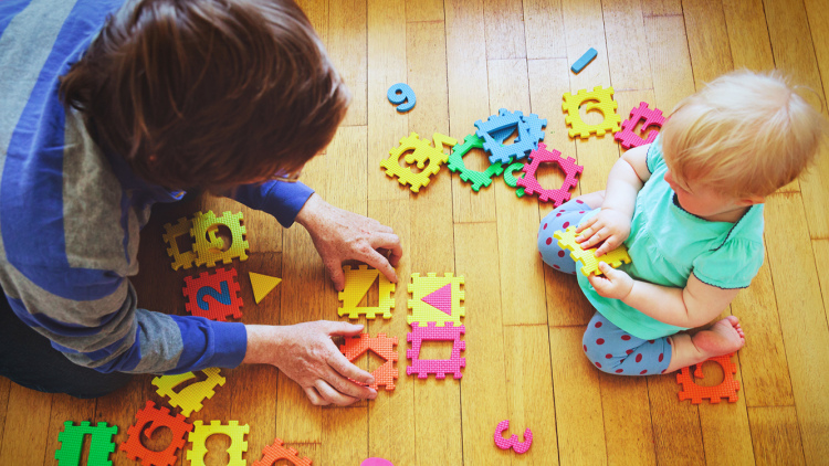 Baby playing on floor with parent