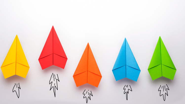 colorful paper airplanes flying upward