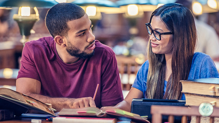 Male and female college student studying in library