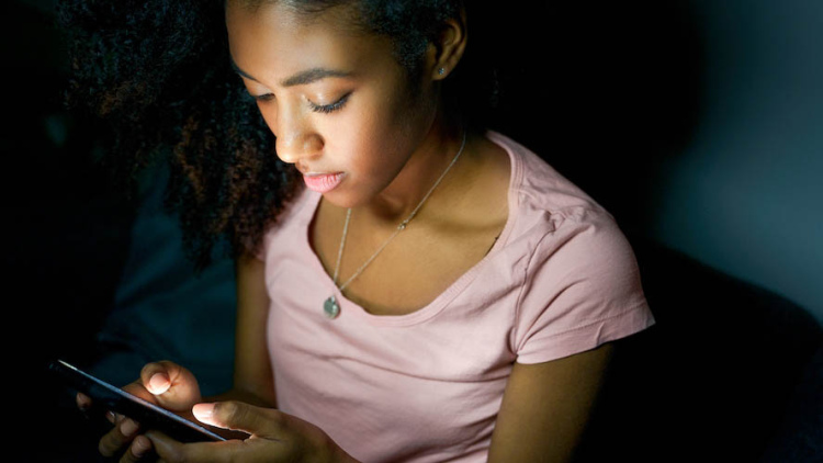 Teen looking down at phone