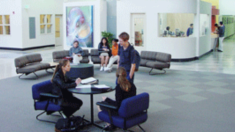photo of a new school building, with students in open lobby area 