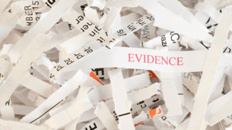 shredded paper with one piece that says evidence