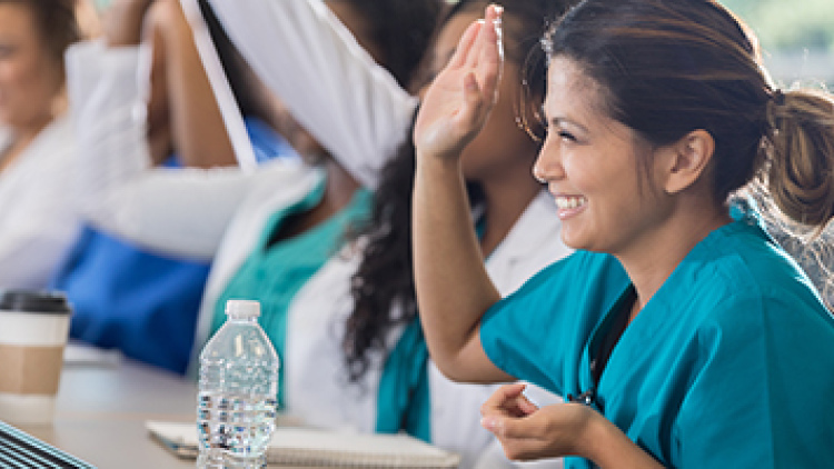 Row of students in medical training class, with smiling woman in front
