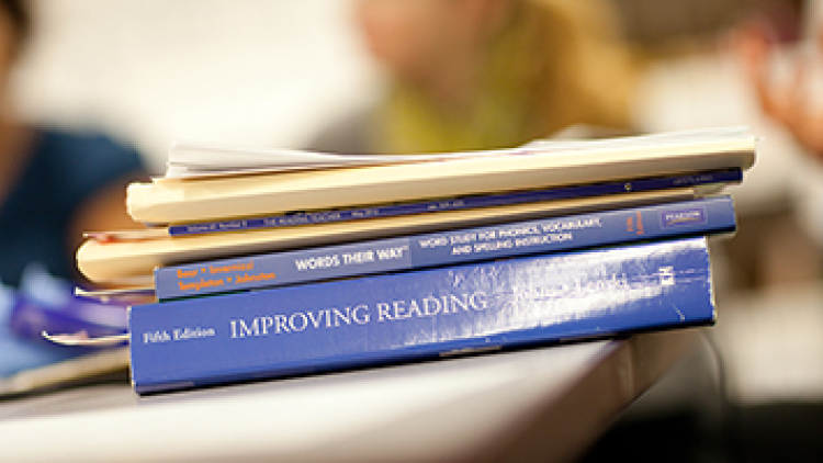 Literacy textbooks stacked on a desk