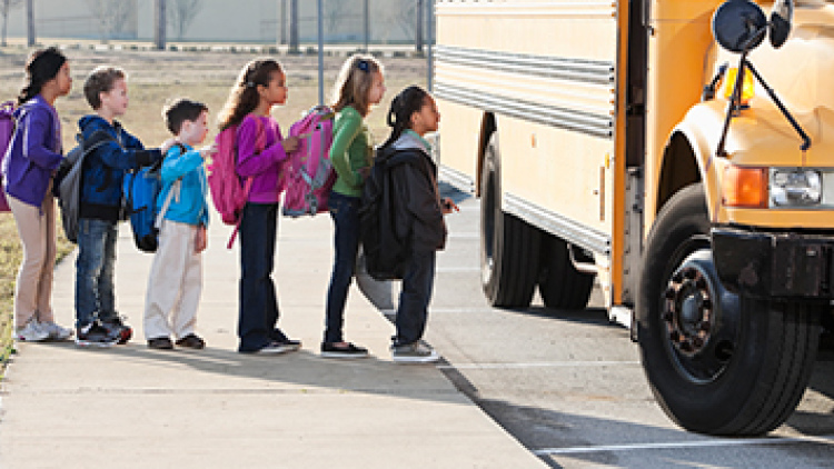 line of children getting onto a school bus