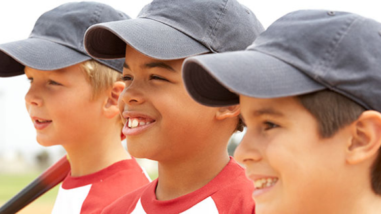 Three boys wearing baseball caps