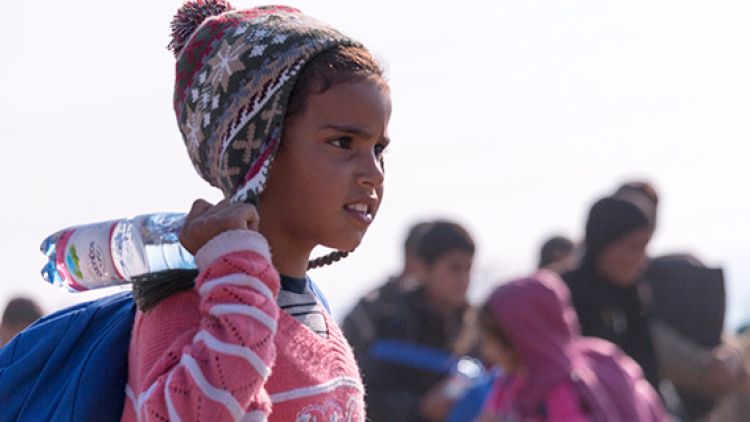 Refugee girl holds water bottle