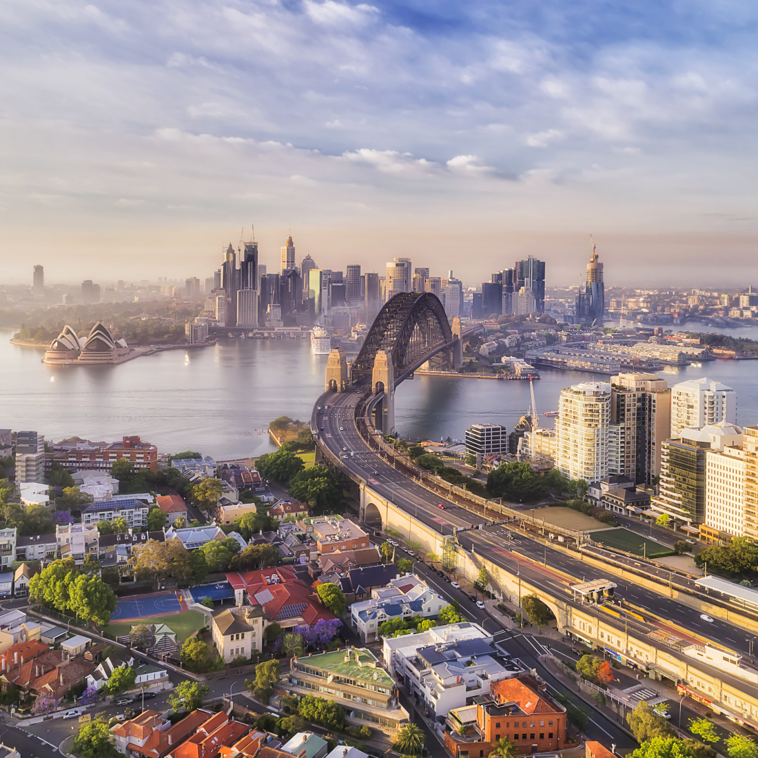 Bird's eye view of the Warringah freeway entering Sydney Harbour bridge along Kirribilli residential suburb on the North Shore, in view of the CBD with major landmarks.