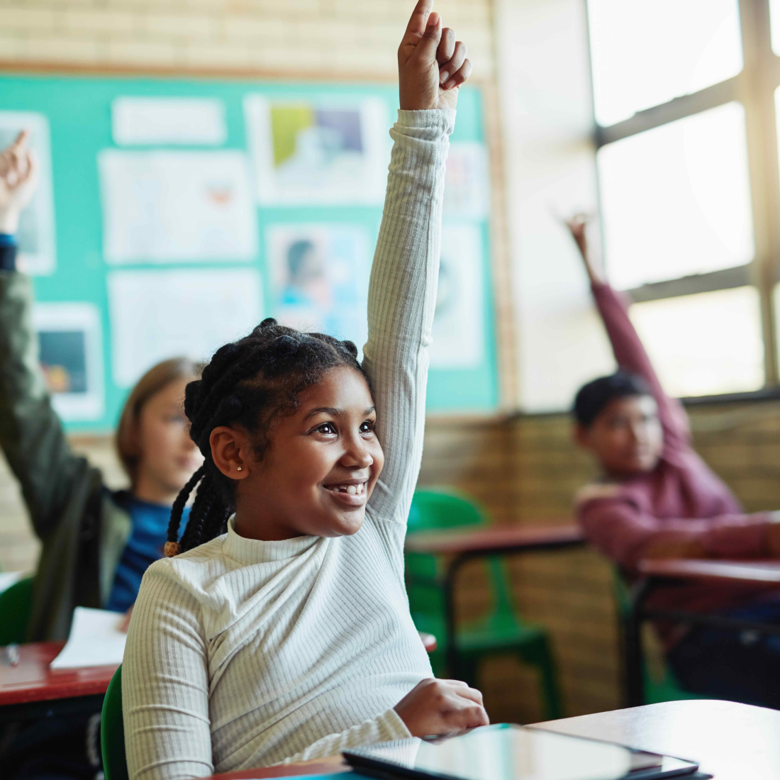 Children raising their hands in a classroom