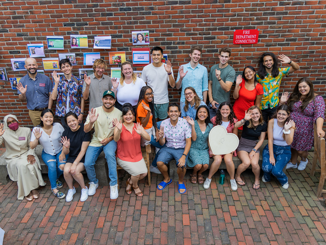 A group of HGSE students pose in front of a brick building.