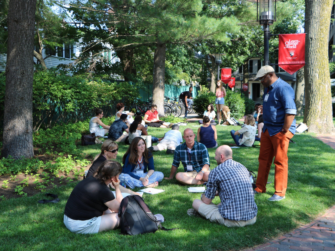Participants sitting in a circle on the grass outside Gutman Library.